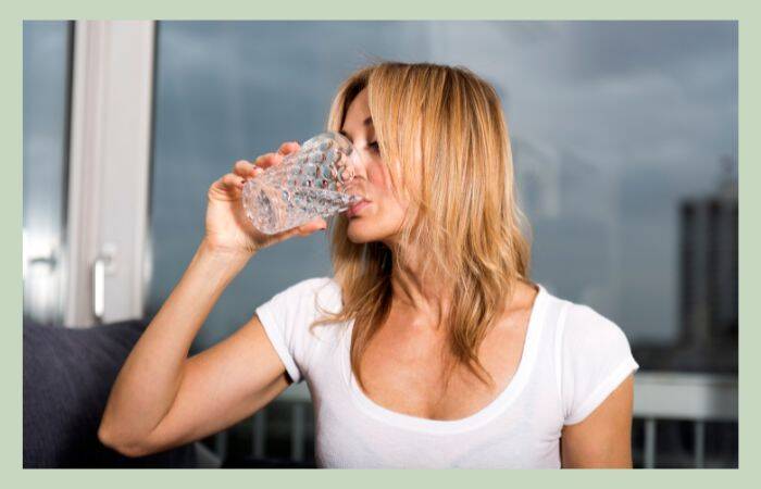 Woman drinking water as part of her post-hysterectomy diet